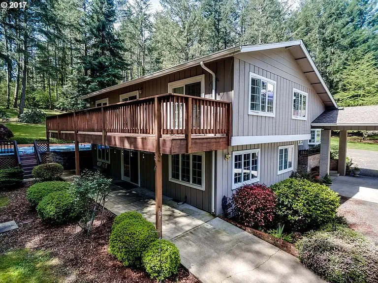 Two-story home with a large elevated wood deck and railing