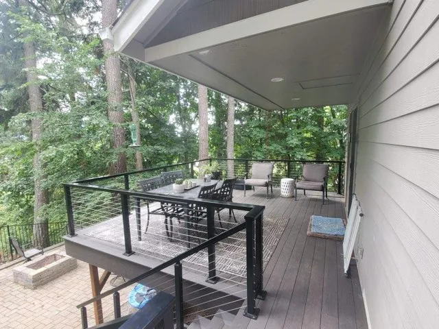 Elevated composite deck with black posts and cable railing