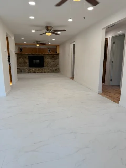 Bright renovated interior with large-format tile floor and stone fireplace